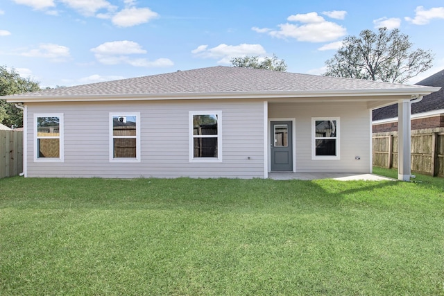 rear view of property featuring a yard and a patio