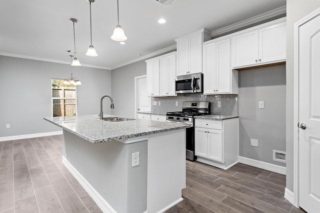 kitchen featuring sink, white cabinets, stainless steel appliances, and a kitchen island with sink