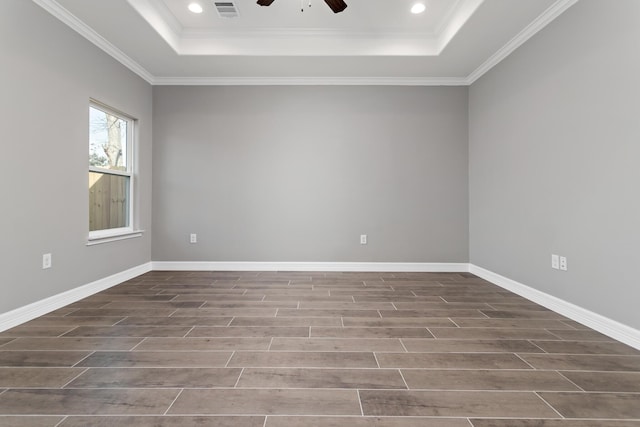 spare room with a raised ceiling, ceiling fan, and ornamental molding