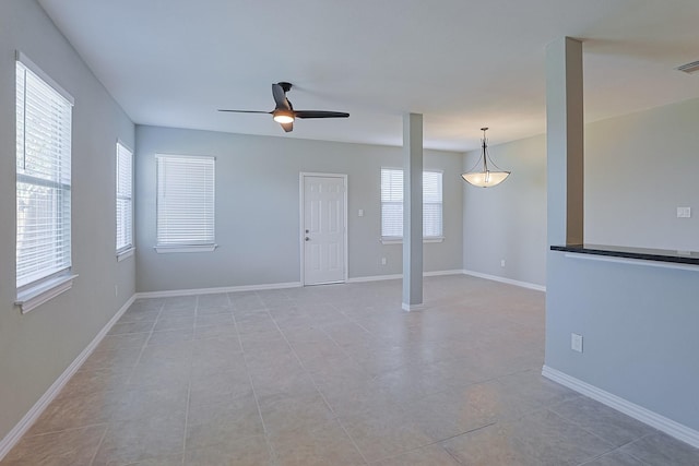 tiled empty room featuring ceiling fan