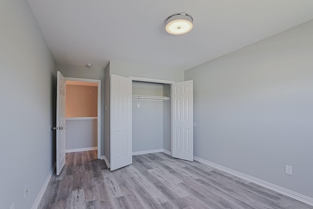 unfurnished bedroom featuring a closet and light hardwood / wood-style floors