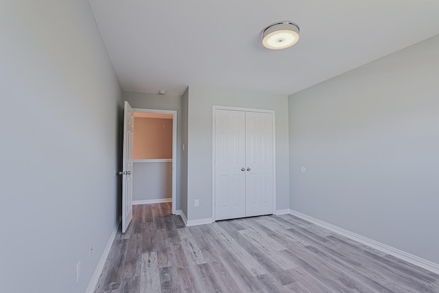 unfurnished bedroom featuring a closet and light hardwood / wood-style flooring