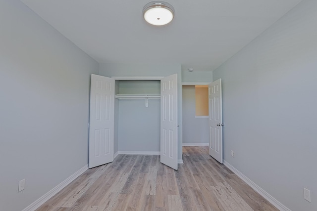 unfurnished bedroom featuring a closet and light hardwood / wood-style floors