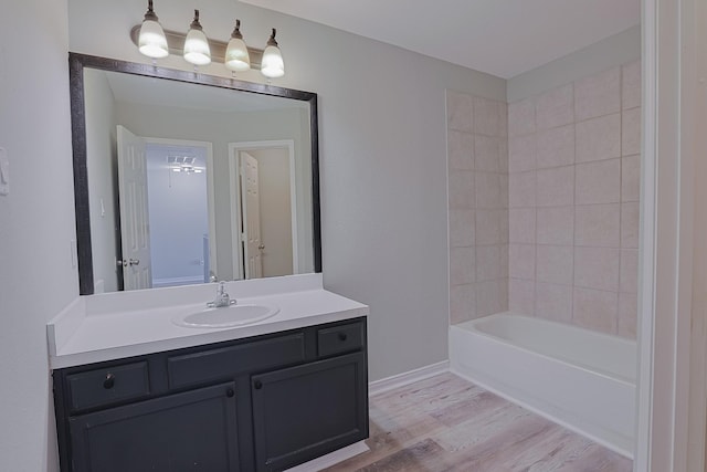 bathroom featuring hardwood / wood-style flooring, tiled shower / bath combo, and vanity