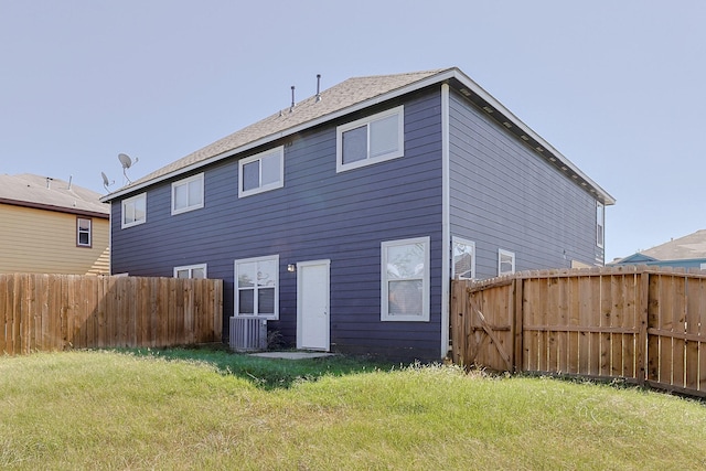 back of house with central AC and a lawn