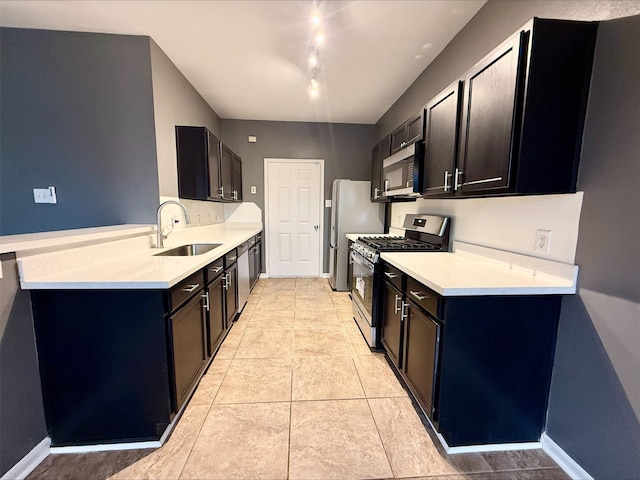 kitchen featuring light tile patterned floors, track lighting, sink, and stainless steel appliances