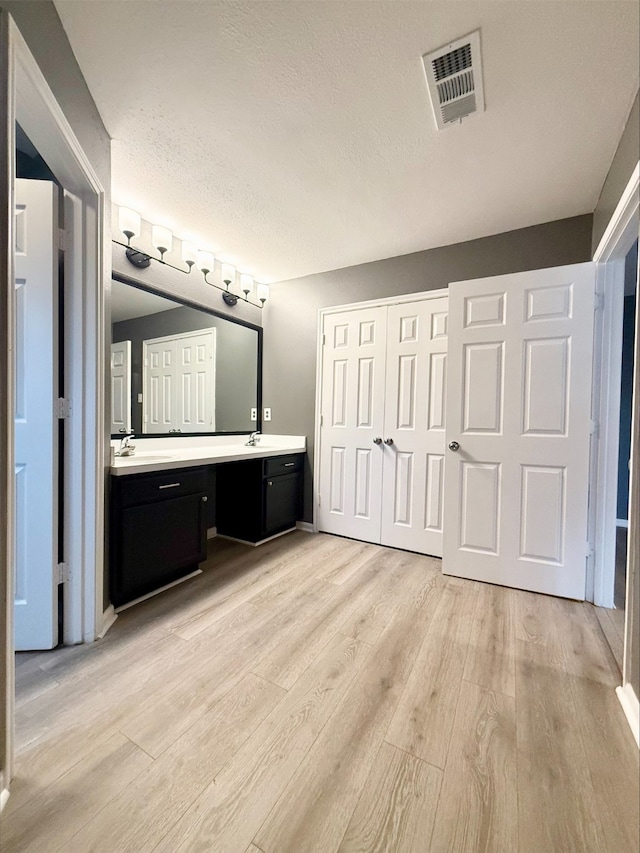 bathroom featuring a textured ceiling, hardwood / wood-style flooring, and vanity