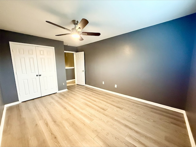 unfurnished bedroom featuring light wood-type flooring, ceiling fan, and a closet