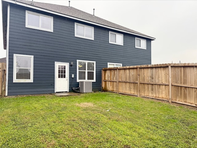 back of property featuring a lawn and central AC unit