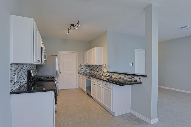 kitchen featuring dark stone countertops, sink, white cabinetry, appliances with stainless steel finishes, and light tile patterned floors