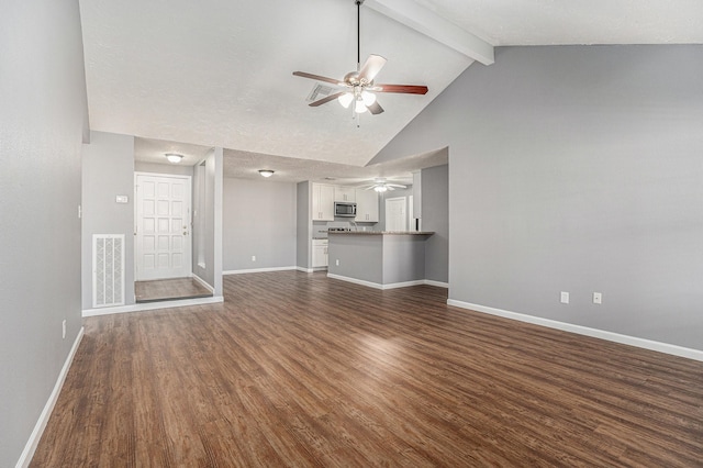 unfurnished living room featuring ceiling fan, a textured ceiling, dark hardwood / wood-style flooring, and beamed ceiling