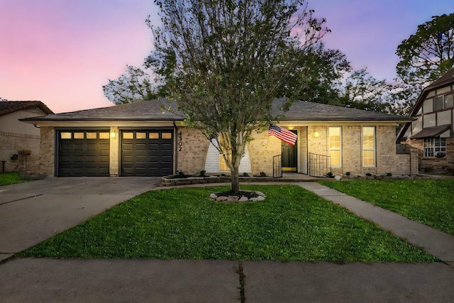 view of front of home with a garage and a yard