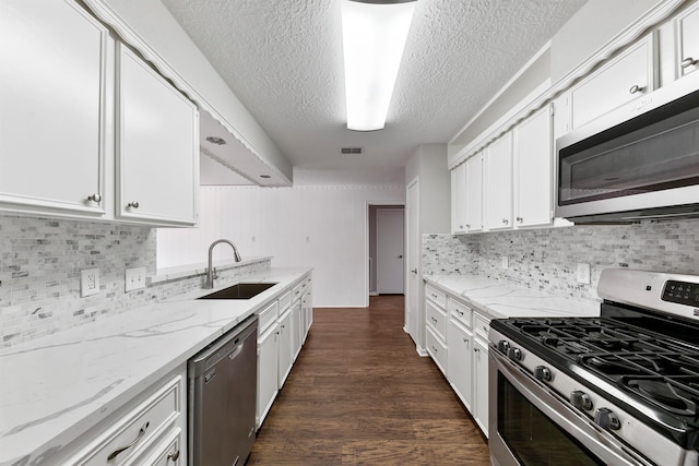 kitchen with light stone counters, sink, white cabinets, and stainless steel appliances