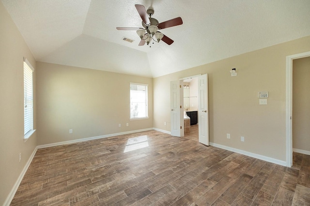 unfurnished bedroom featuring lofted ceiling, baseboards, visible vents, and dark wood-type flooring