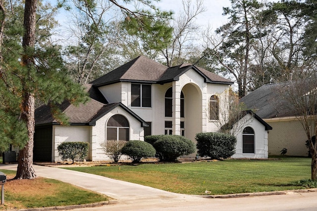 27210 Afton Way, Huffman, TX 77336 - traditional-style house with brick siding, roof with shingles, a front lawn, driveway, and an attached garage