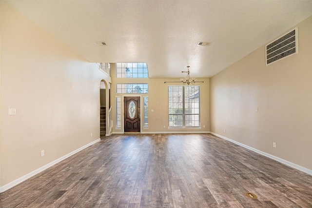 entrance foyer featuring baseboards, visible vents, dark wood-type flooring, stairs, and a notable chandelier