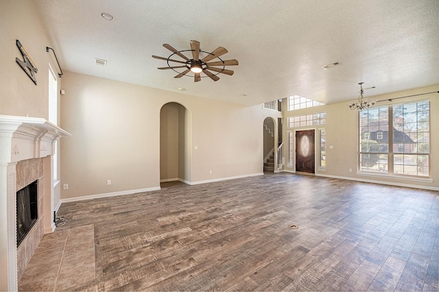 27210 Afton Way, Huffman, TX 77336 - unfurnished living room with arched walkways, a high end fireplace, wood finished floors, a ceiling fan, and a textured ceiling