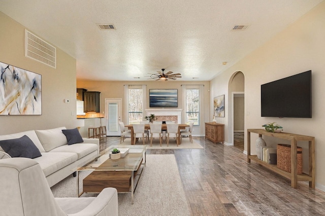 27210 Afton Way, Huffman, TX 77336 - living area featuring wood finished floors, a ceiling fan, a textured ceiling, baseboards, and arched walkways