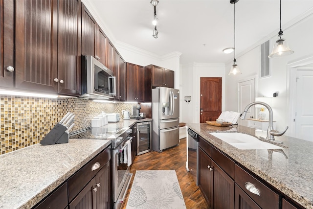 kitchen featuring light stone countertops, appliances with stainless steel finishes, crown molding, and sink