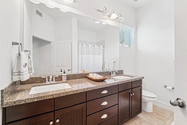 bathroom with toilet, tile patterned flooring, and vanity