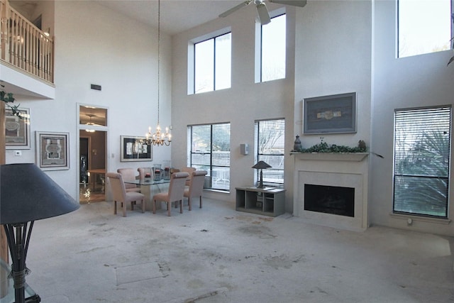 living room featuring ceiling fan, carpet, and a towering ceiling