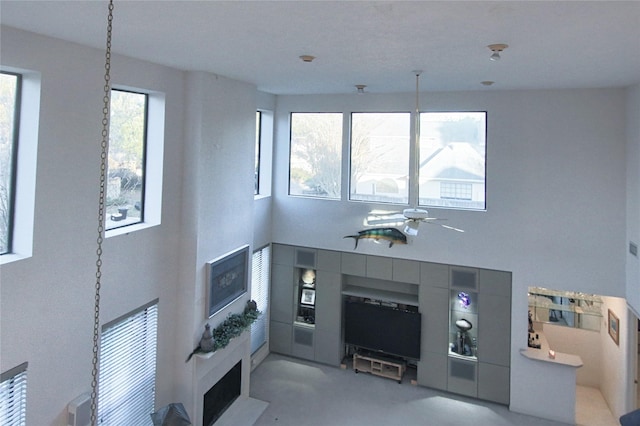 living room with ceiling fan and a towering ceiling