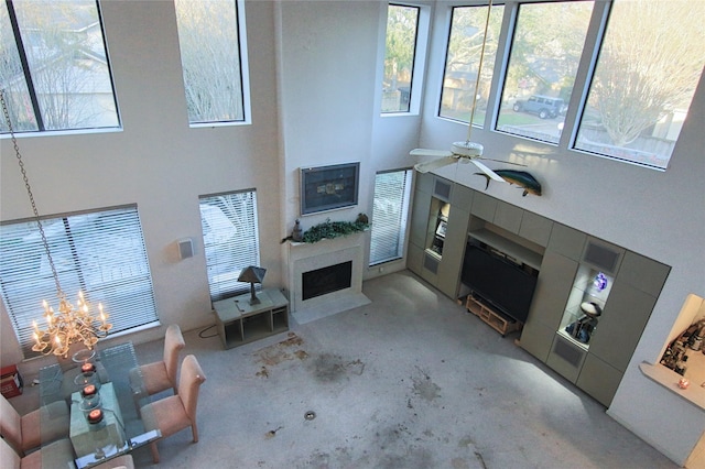 living room featuring ceiling fan with notable chandelier and a towering ceiling