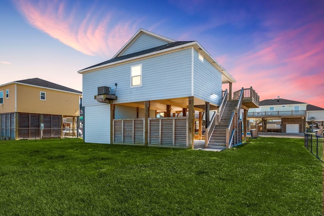 back house at dusk with a lawn