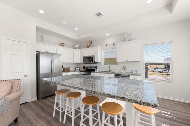 kitchen featuring white cabinetry, appliances with stainless steel finishes, a center island, and sink