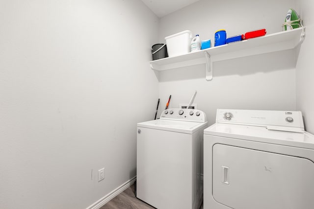 clothes washing area with washing machine and clothes dryer and wood-type flooring