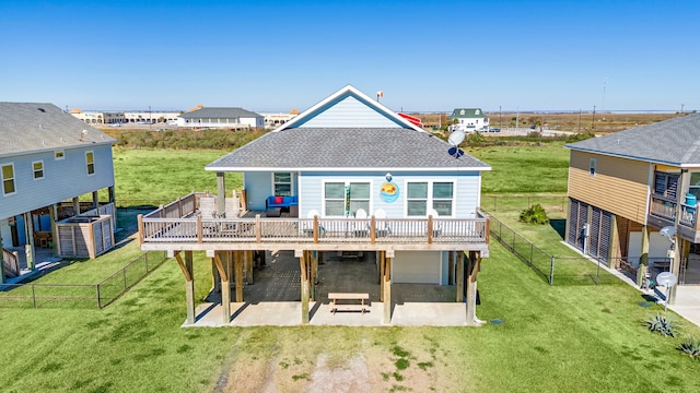 back of property featuring a patio, a wooden deck, and a lawn