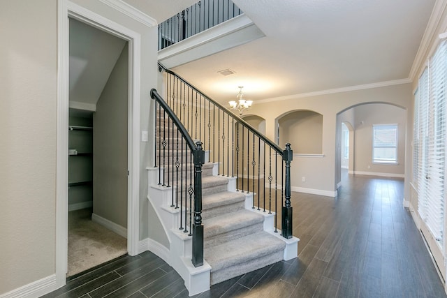 stairway featuring a chandelier and crown molding