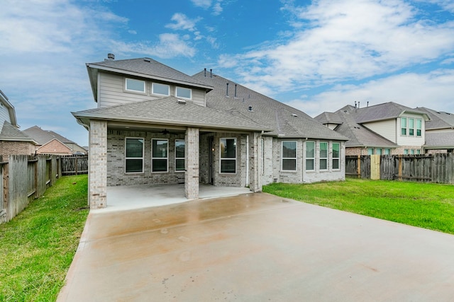 back of property featuring a patio area and a lawn