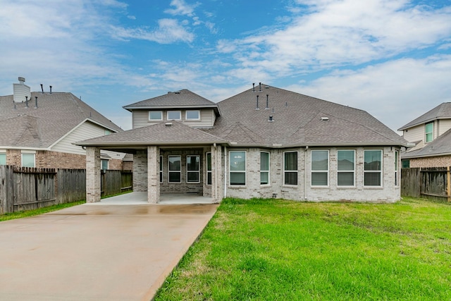 rear view of property featuring a lawn and a carport