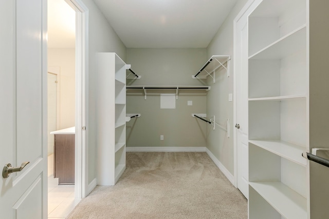 walk in closet featuring light colored carpet