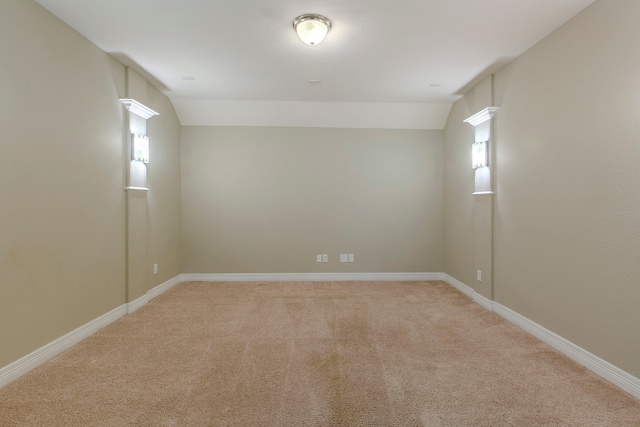 unfurnished room featuring light colored carpet and lofted ceiling