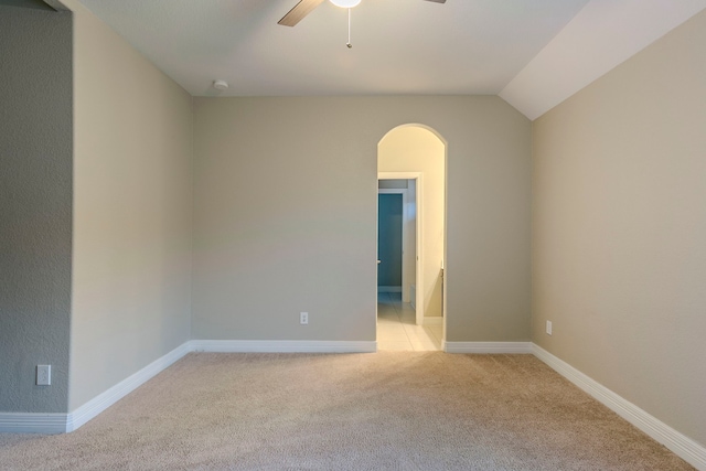 carpeted spare room with ceiling fan and lofted ceiling