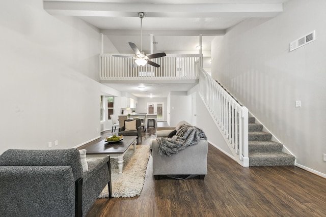 living room featuring ceiling fan, dark wood-type flooring, a high ceiling, and beamed ceiling