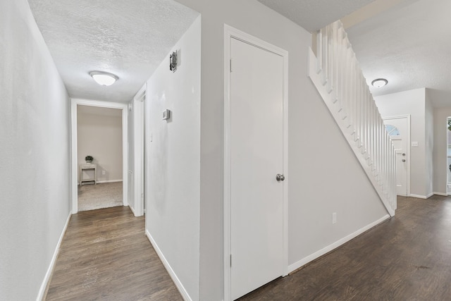 corridor featuring dark hardwood / wood-style floors and a textured ceiling