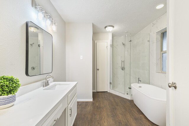 bathroom featuring hardwood / wood-style flooring, a textured ceiling, vanity, and separate shower and tub