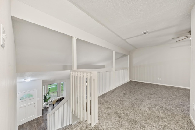 spare room with lofted ceiling, ceiling fan, a textured ceiling, and carpet flooring