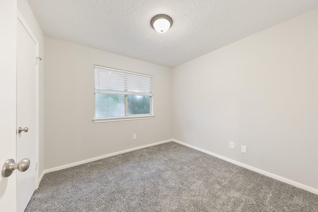 carpeted empty room with a textured ceiling