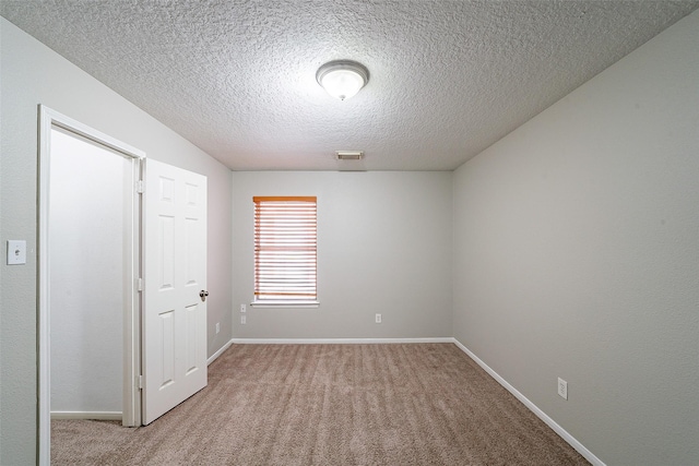 carpeted spare room featuring a textured ceiling