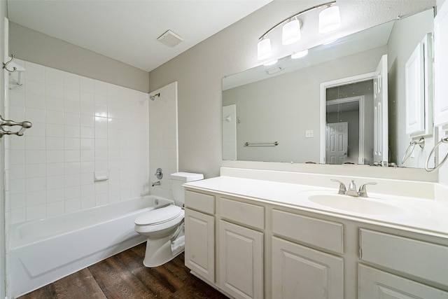 full bathroom with toilet, tiled shower / bath combo, vanity, and hardwood / wood-style flooring