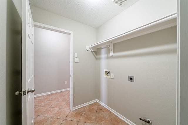 washroom featuring a textured ceiling, electric dryer hookup, hookup for a washing machine, light tile patterned floors, and gas dryer hookup