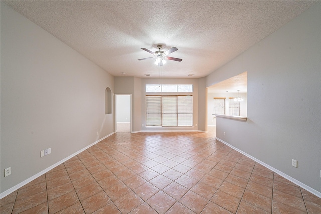 tiled empty room with ceiling fan and a textured ceiling