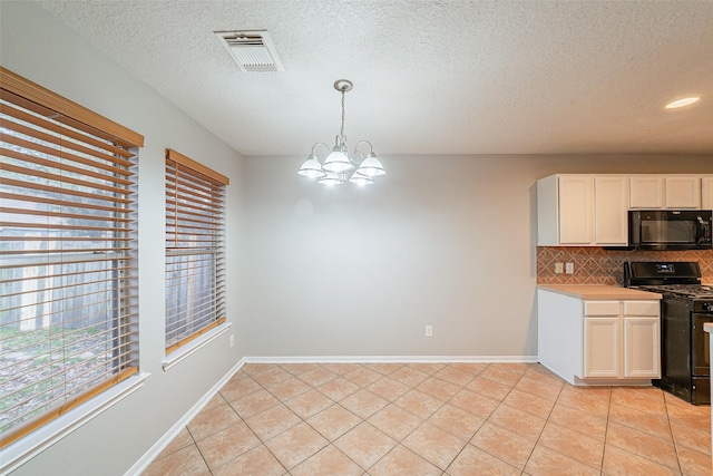 kitchen featuring tasteful backsplash, black appliances, white cabinetry, hanging light fixtures, and a chandelier