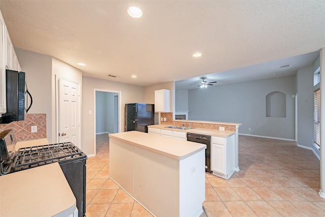 kitchen with white cabinets, black appliances, a center island, decorative backsplash, and light tile patterned floors