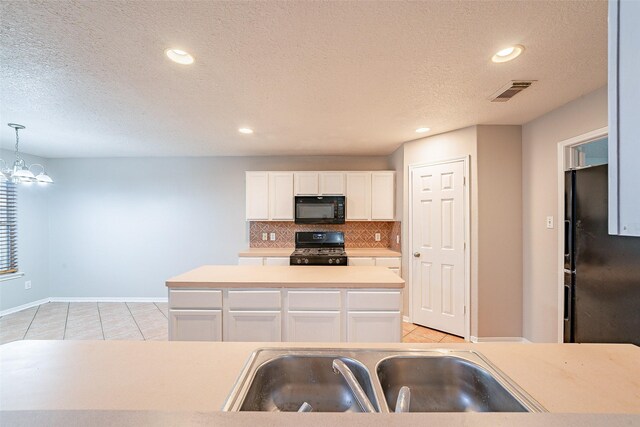 kitchen with light tile patterned floors, white cabinetry, a kitchen island, pendant lighting, and black appliances