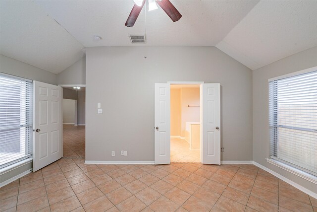 unfurnished bedroom featuring vaulted ceiling, ceiling fan, and light tile patterned floors